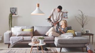 คนสองคนนั่งอยู่บนโซฟาที่บ้านเพลิดเพลินกับไฟ LED คุณภาพสูง